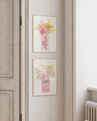 Framed artwork of a Coca-Cola bottle with floral design on a wall.