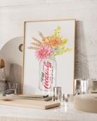 Framed artwork of a Coca-Cola bottle with flowers on a kitchen counter.